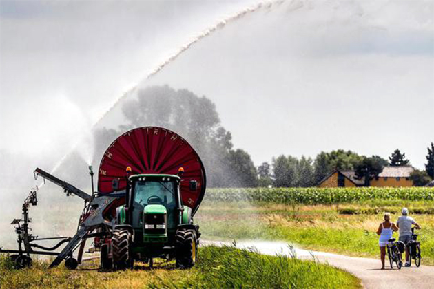 Tractor met sproeier en fietsers